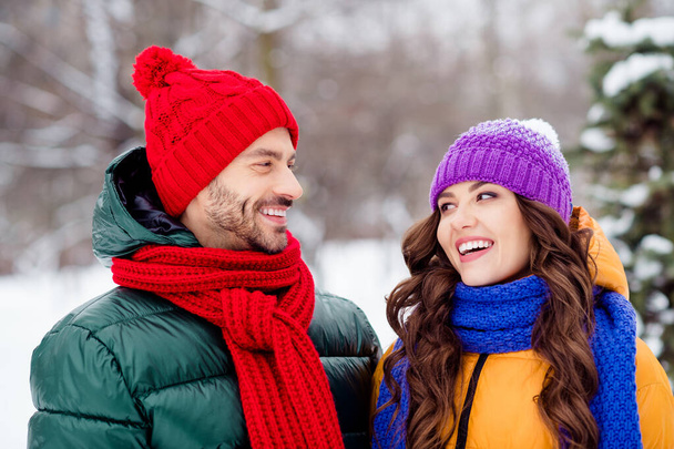 Photo of cute adorable girlfriend boyfriend dressed vests smiling looking each other laughing walking snow outdoors forest - Foto, Imagen