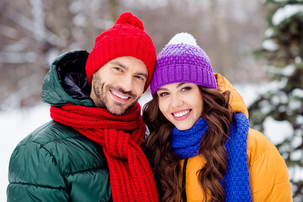 Photo of charming pretty marriage couple wear windbreakers enjoying snowy weather embracing smiling outside park - Photo, image