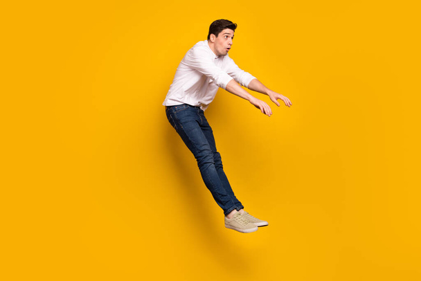 Full size profile photo of sad brunet millennial guy fall wear shirt jeans sneakers isolated on yellow background - Photo, image