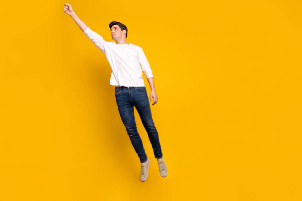 Full length body size photo man jumping up flying like superman isolated vivid yellow color background - Foto, Imagen
