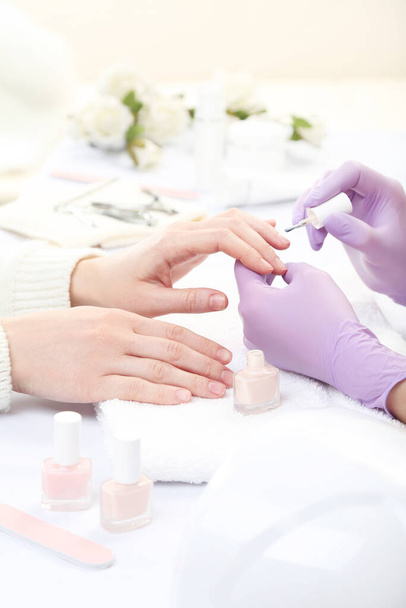 Manicurist in gloves making manicure for client in salon - Fotoğraf, Görsel