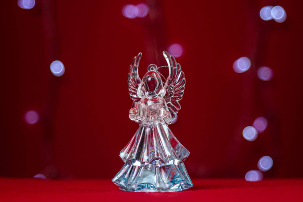 Enkelin lasinen veistos juhlallisella taustalla. Joulun ja uskonnollisen loman käsite - Valokuva, kuva