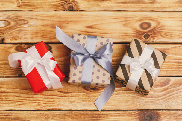 Small christmas gifts on wooden background, view from above - 写真・画像