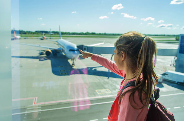 Dziecko na lotnisku patrzy na samolot. Wybiórcze skupienie. Dzieciaku.. - Zdjęcie, obraz