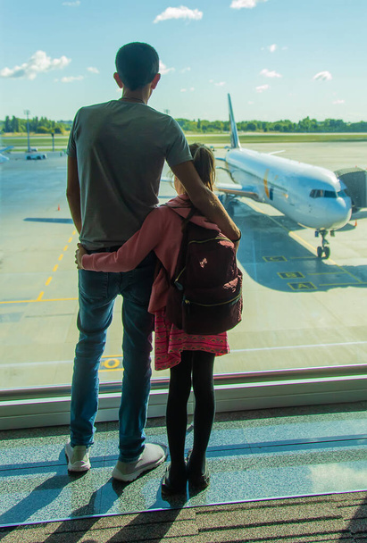 Een kind op het vliegveld kijkt naar het vliegtuig. Selectieve focus. Jongen. - Foto, afbeelding