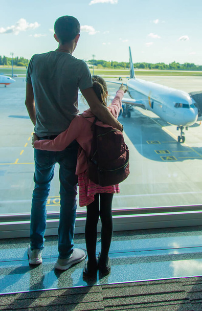 A child at the airport looks at the plane. Selective focus. Kid. - Photo, Image