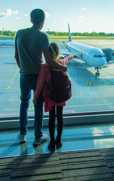 Ребенок в аэропорту смотрит на самолет. Выборочный фокус. Kid. - Фото, изображение
