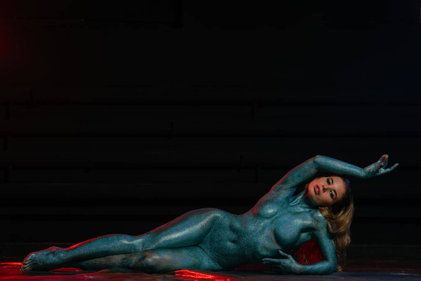 Gorgeous naked brunette posing painted in turquoise sequins. - Foto, Imagem
