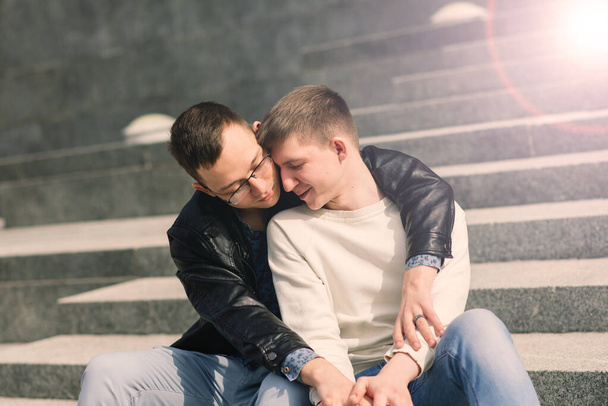 Cute gay couple in a city, tender gentle kissing, smiling - Photo, Image