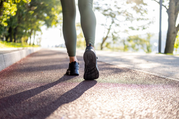 lähikuva nainen jalat urheilu lenkkarit käynnissä puistossa auringonnousun aikaan. Terveellinen kunto elämäntapa. - Valokuva, kuva