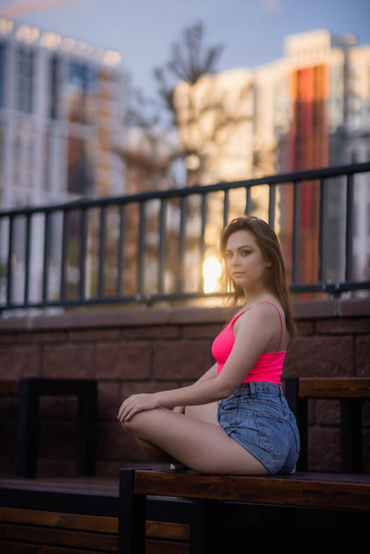 Portrait of a young pretty woman in blue shorts residential complex. - Photo, image