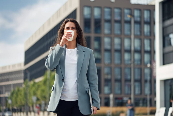 Young beautiful business woman at casual clothes near office centre with cup of coffee. Lunch break among working day. Business lifestyle and success concept. - Foto, Imagem