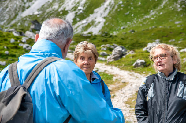 Idosos relaxando no final de uma caminhada na montanha, conversando ao longo da trilha alpina - Foto, Imagem