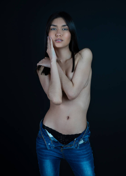 slim woman with black hair covering her breast with her hands and looking at camera - Fotografie, Obrázek