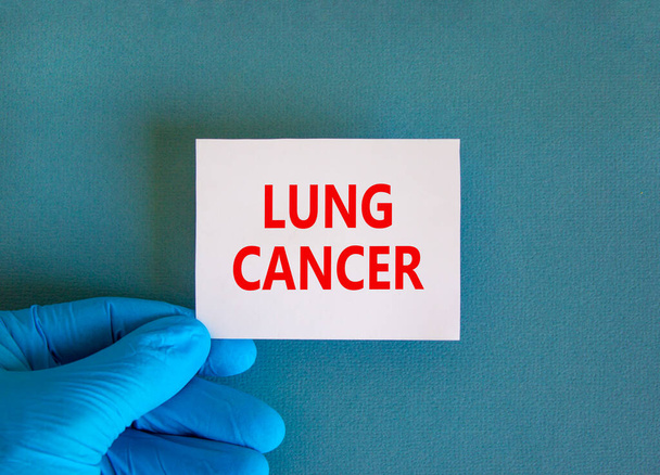 Lung cancer symbol. White note with words Lung cancer, beautiful blue background, doctor hand in blue glove. Medical and lung cancer concept. - Foto, Imagem