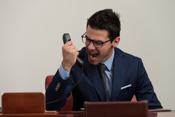 rozhněvaný muž v formální oblečení, křičí na telefon - Fotografie, Obrázek