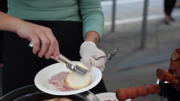 Γυναίκα κανόνισε ψωμί και φέτες ζαμπόν στο πιάτο. Αυτό το ζαμπόν στα ιταλικά λέγεται προσούτο κότο. - Πλάνα, βίντεο