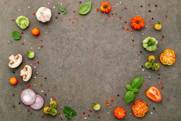 The ingredients for homemade pizza set up on dark stone background. - Photo, Image