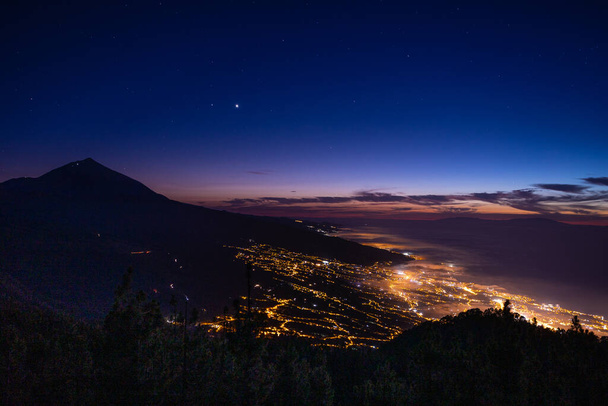 The aerial view of the night city lights and the mountain. - Photo, Image