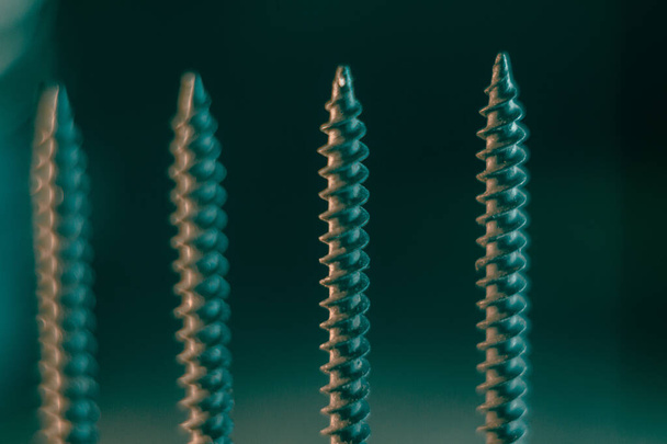A pile of screws on a blurred background - Zdjęcie, obraz