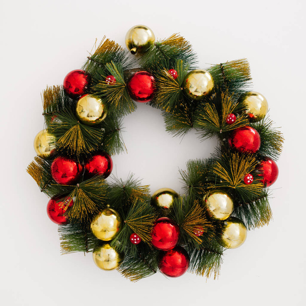 A closeup of a festive Christmas wreath with baubles on a white background - Valokuva, kuva