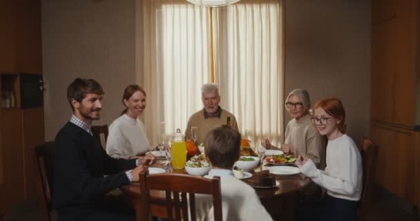 The family joins hands for prayer before the family dinner - Video