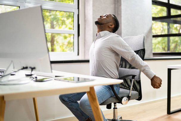 Employee Stretching At Office Desk At Work - Valokuva, kuva