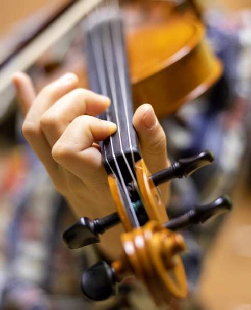 το χέρι ενός νεαρού βιολιστή που κρατά το λαιμό και πιέζει τα έγχορδα παίζοντας βιολιά, οριζόντια - Φωτογραφία, εικόνα