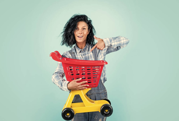 happy pretty woman with brunette hair wear casual clothes carry shopping cart, sale - Photo, image