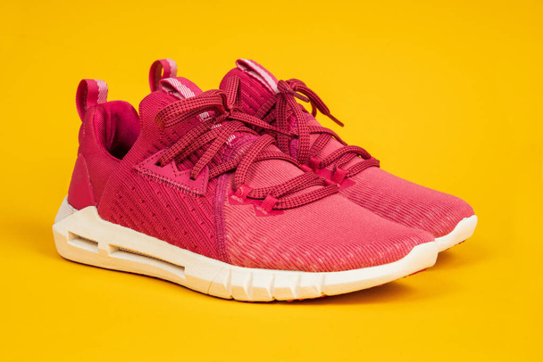 Coppia di nuove sneakers rosa, scarpe sportive su sfondo giallo. Rosa donna sport, scarpe da corsa - Foto, immagini
