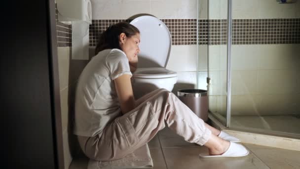 Giovane donna seduta vicino alla toilette - Filmati, video