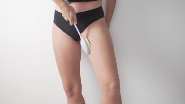Nahaufnahme der Beine einer vollwertigen Frau bei einer Massage mit einer speziellen Bürste gegen die Bildung von Cellulite - Filmmaterial, Video