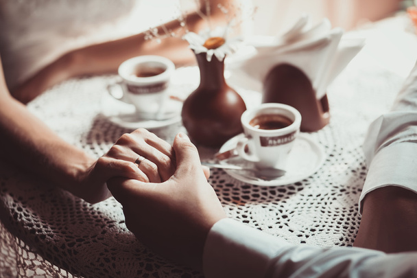 Casal apaixonado beber café no café, segurando a mão um do outro
. - Foto, Imagem
