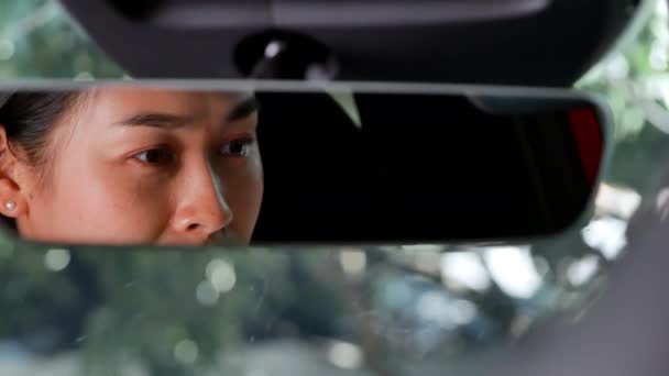 Der Blick aus dem Rückspiegel einer gestressten und erschöpften Frau, die im Auto weint. Überarbeitetes Fahrerkonzept. - Filmmaterial, Video