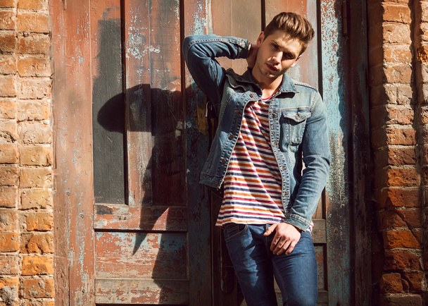 Hipster style guy. Fashion man standing near a wooden door - Foto, Imagem
