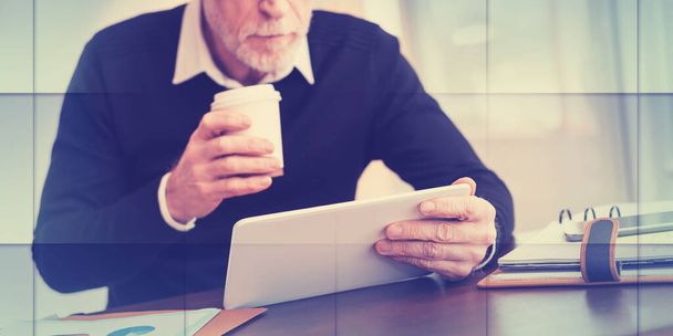 Старший бизнесмен, работающий над цифровым планшетом в офисе, геометрический шаблон - Фото, изображение