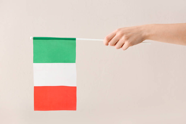 Main féminine avec drapeau national de l'Italie sur fond clair - Photo, image
