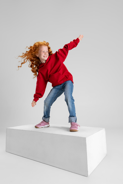 Portrait of little girl, child standing in pose of surfer isolated over gray studio background. - Foto, immagini