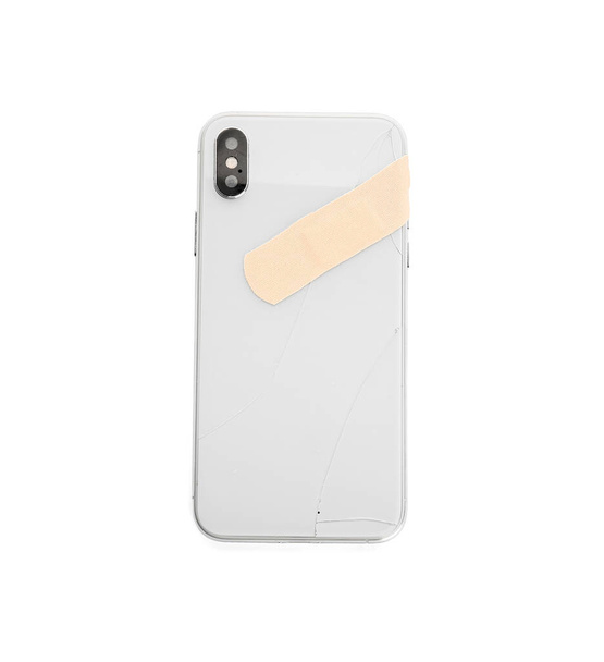 Teléfono móvil roto con yeso médico sobre fondo blanco - Foto, Imagen