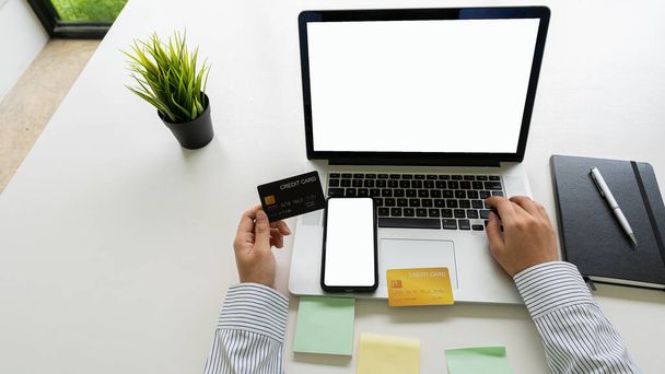 Geschäftsmann mit Laptop mit weißem Bildschirm, um sich mit Kreditkarte anzumelden, um online einzukaufen und online mit Kreditkarte einzukaufen. Ideen für Online-Einkäufe - Foto, Bild