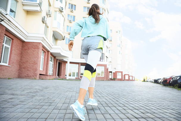 Sporty young woman running outdoors - Фото, зображення