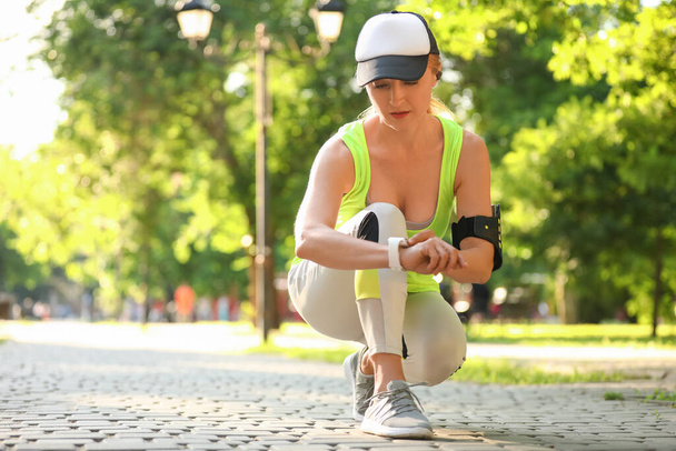 Sportos érett nő fitness tracker szabadban - Fotó, kép