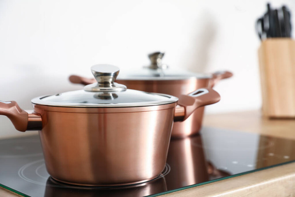 Copper cooking pot on stove in kitchen, closeup - Photo, Image