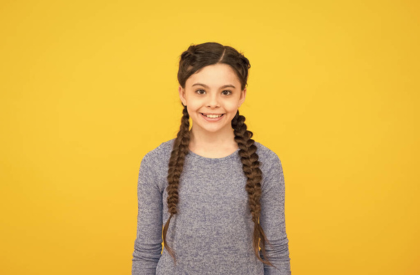 happy teen girl with braided hair wear casual style on yellow background, fashion - Photo, Image