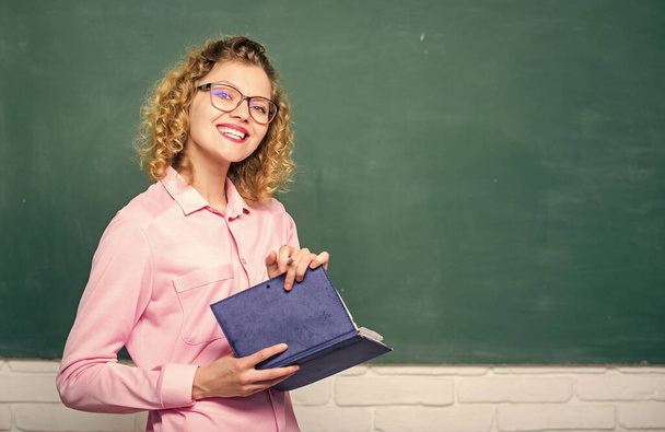 Teacher explain hard topic. Pedagogue hold book and explaining information. Education concept. Woman school teacher in front of chalkboard. Teacher best friend of learners. Passionate about knowledge - Foto, imagen