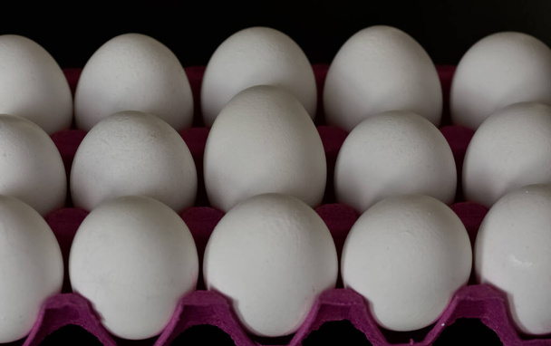Huevos de pollo blancos sobre fondo negro. - Foto, Imagen