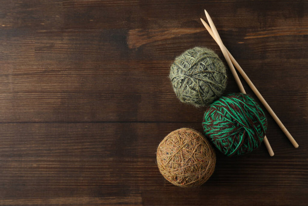Yarn balls and knitting needles on wooden background - Valokuva, kuva