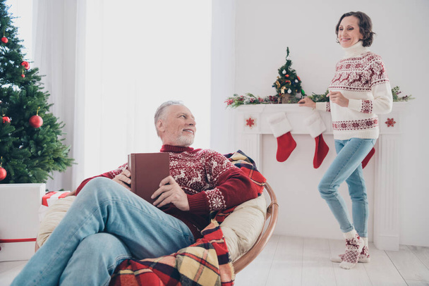 Photo of funny sweet mature lovers wear knitted sweaters smiling reading listening christmas story indoors house home room - Foto, immagini