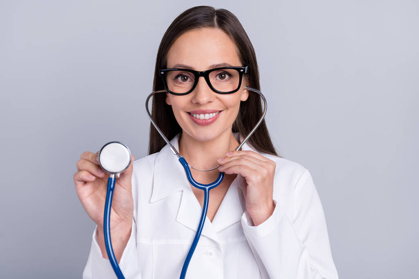 Photo of mature woman happy positive smile listen stethoscope diagnostic patient isolated over grey color background - Fotó, kép