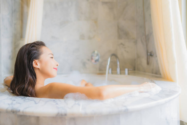 Retrato hermosa joven mujer asiática relajarse tomar un baño en la bañera en el interior del baño
 - Foto, Imagen
